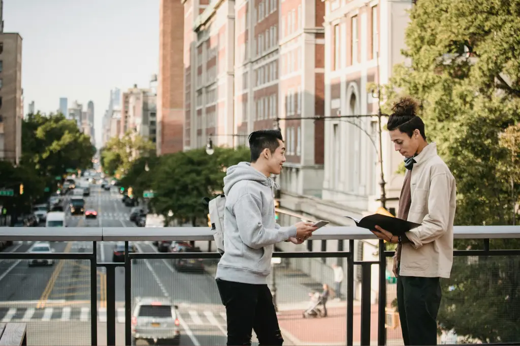 Two people reading outdoors on a balcony. Two people reading outdoors on a balcony.