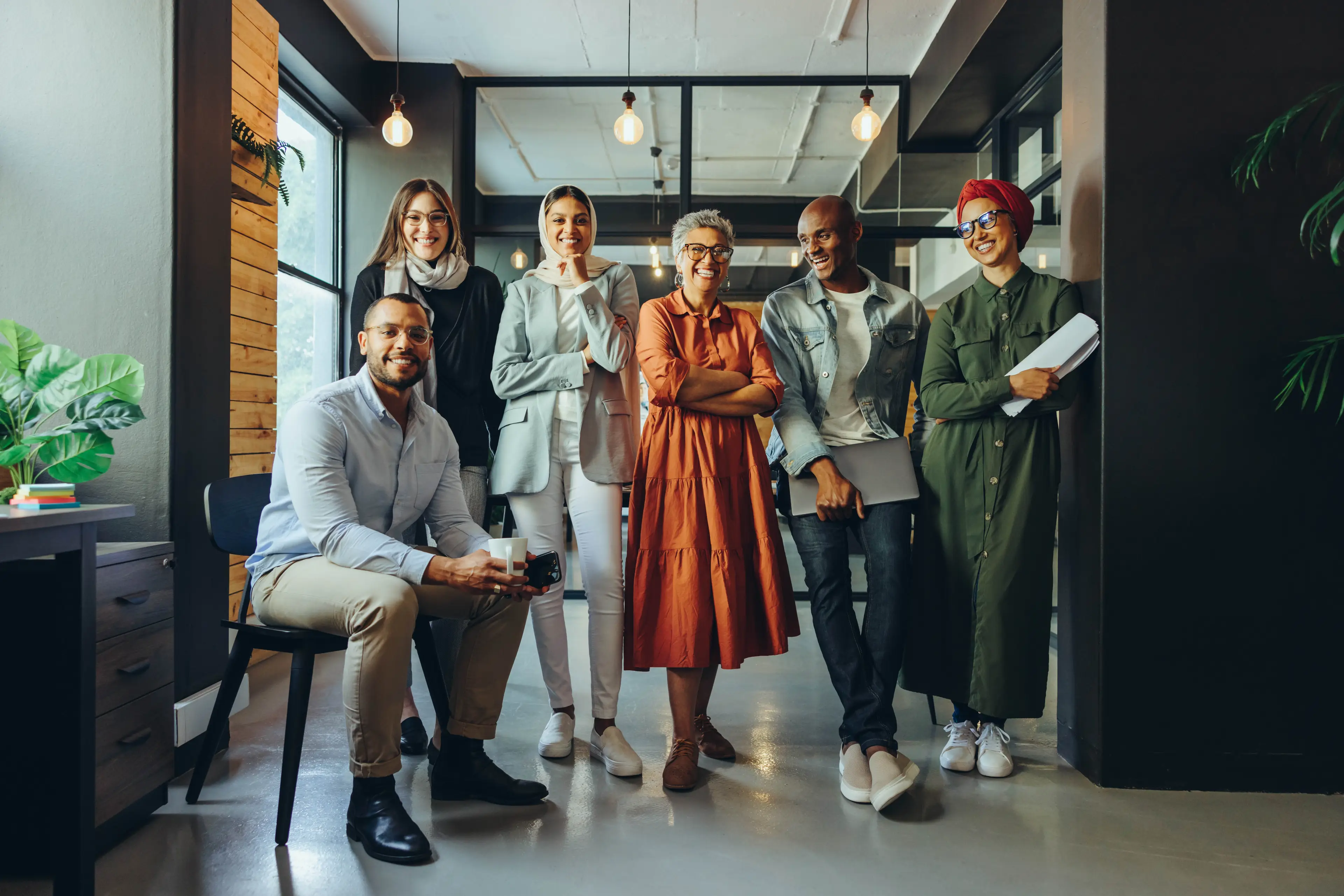Diverse team standing together in office. Diverse team standing together in office.
