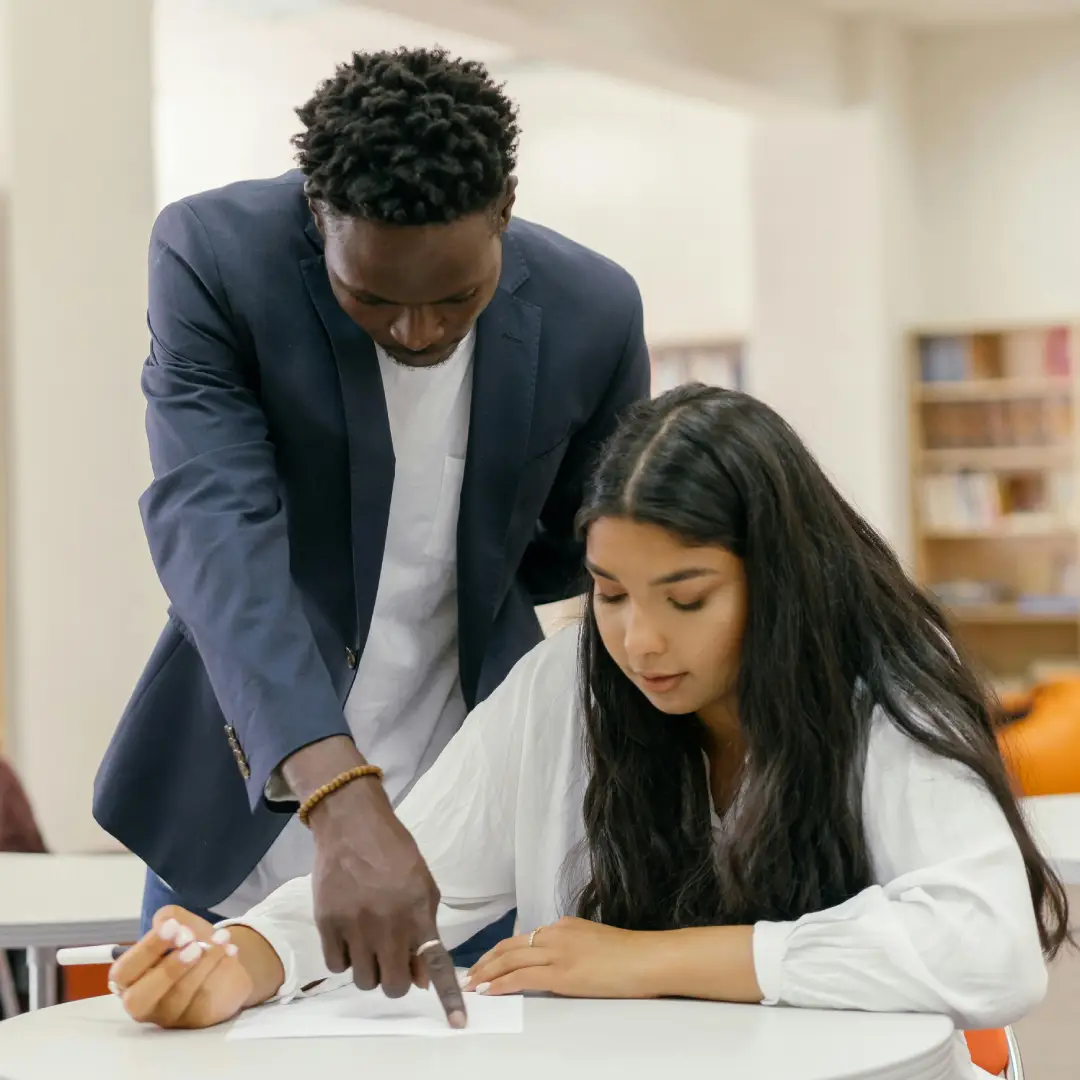 Man assisting woman with work at desk. Man assisting woman with work at desk.