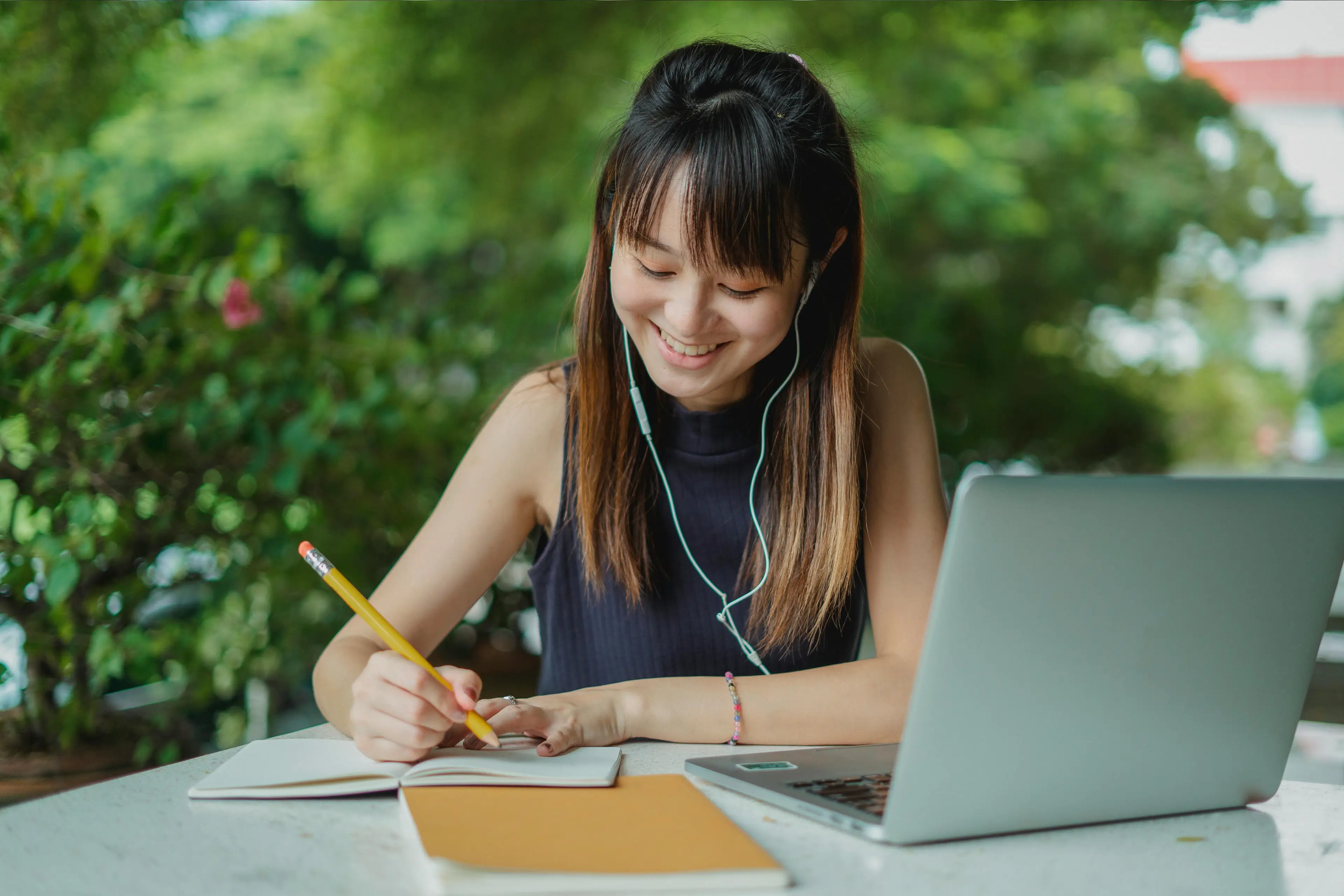 Woman studying with laptop and notebook outdoors. Woman studying with laptop and notebook outdoors.