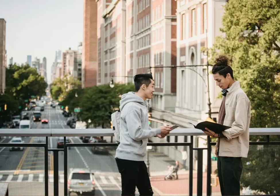 Two people reading outdoors on a balcony. Two people reading outdoors on a balcony.